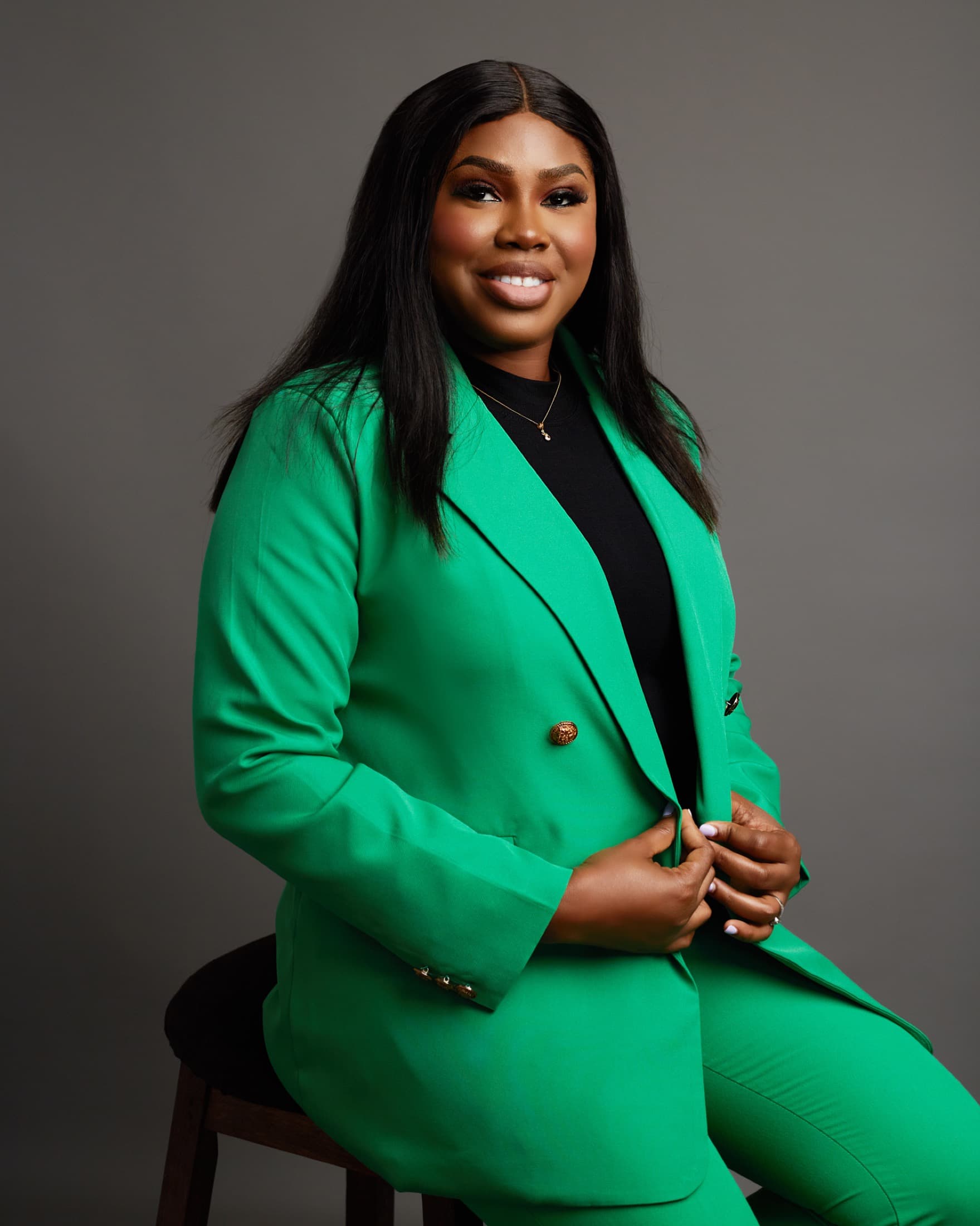 Fredericka Doku in an emerald suit, seated in the studio