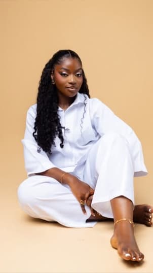 Dora Wilkinson sitting on the floor in a white shirt and trousers